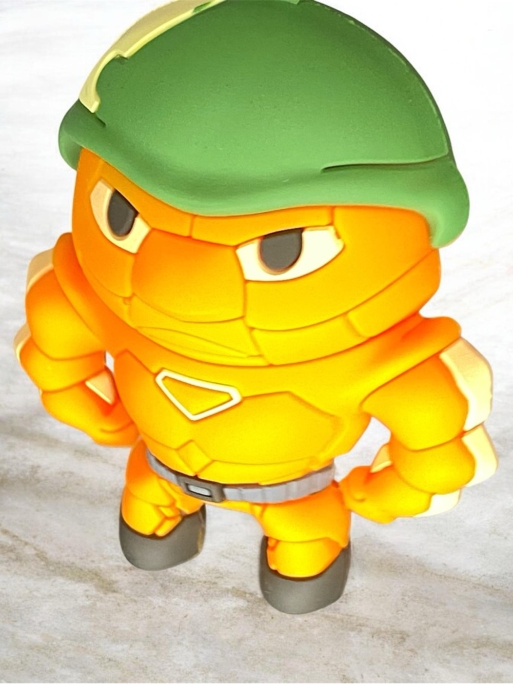 Orange Vinyl Figure Toy with Green Helmet